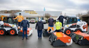 De dienst Technisch Onderhoud van de gemeente Koksijde krijgt er twee mini-wielladers bij. Ze worden o.a. ingezet voor het reinigen van de Zeedijk. Deze bobcats zijn uitgerust met een schep- en borstelbak en een zandschuif en ze voldoen aan de recentste veiligheidsnormen. Gebruiksgemak en ergonomie waren prioritair bij de aankoop van de nieuwe machines. • Foto ©Olivier Tilmant – Lokaal Bestuur Koksijde met burgemeester Marc Vanden Bussche, regionaal sales manager Kristof Decroos - Vangaever NV en enkele medewerkers van de dienst Technisch Onderhoud.